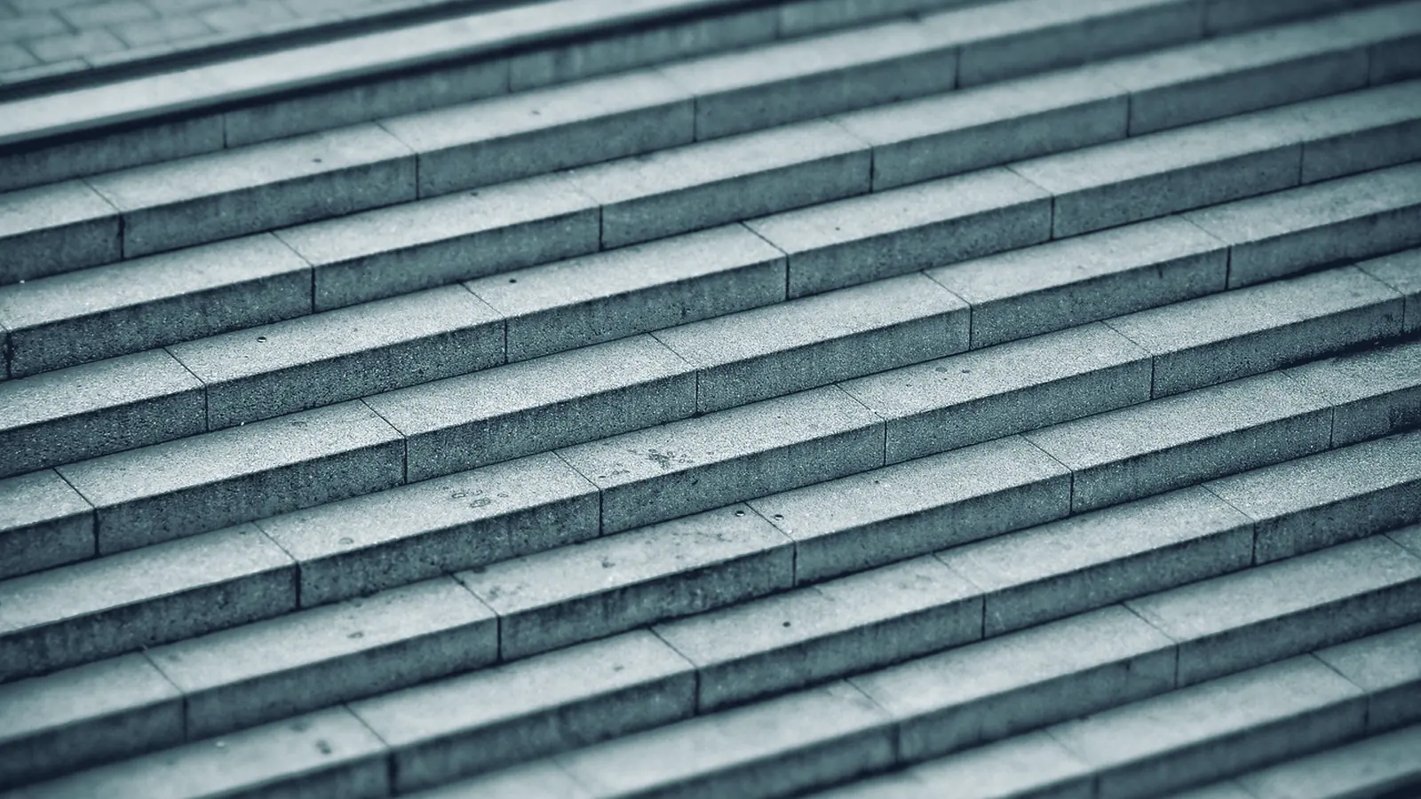 Breite Steintreppe mit gleichmäßigen Stufen in schrägem Licht