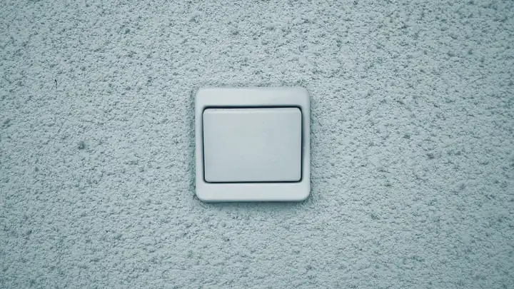 Ein einzelner Lichtschalter an einer verputzten Wand